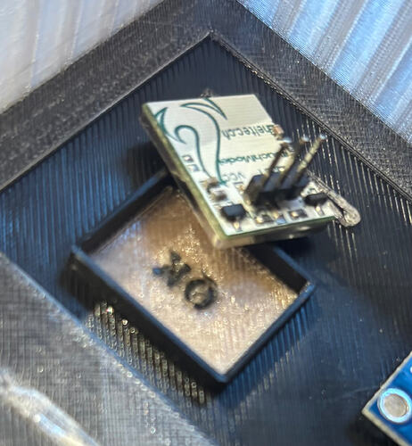 Inside view of a 3D-printed enclosure showing a capacitive touch module placed directly behind the wall. The housing features a separate, slightly transparent rectangular touch area with an "OK" label, ensuring a minimal air gap between the sensor and the surface.