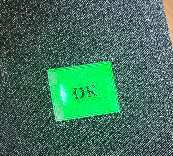 Exterior view of the enclosure with the power on. A bright green LED from the internal sensor shines clearly through the transparent touch area, illuminating the "OK" symbol and providing instant visual feedback through the solid wall.